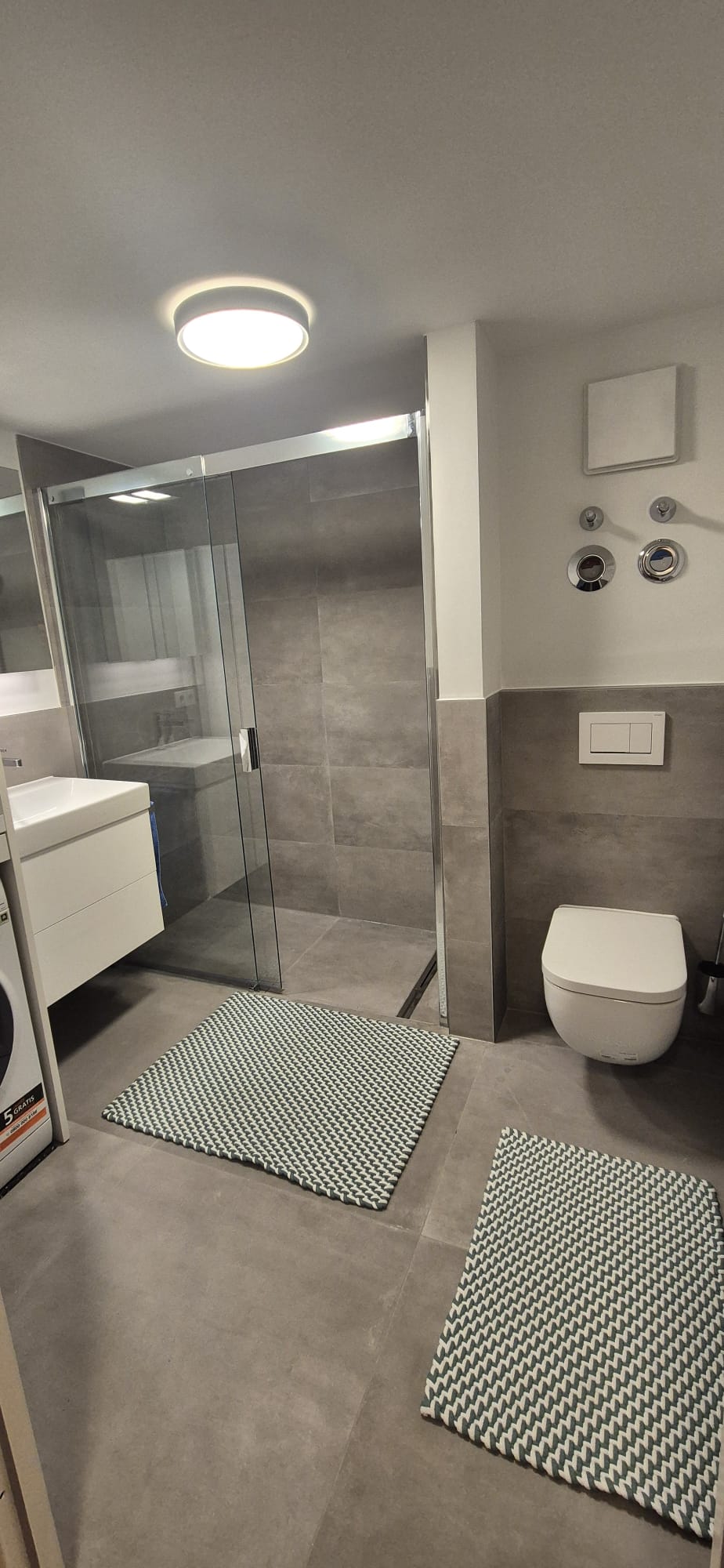 Modernes Badezimmer mit wandhängendem WC und grauer Fliesengestaltung in München