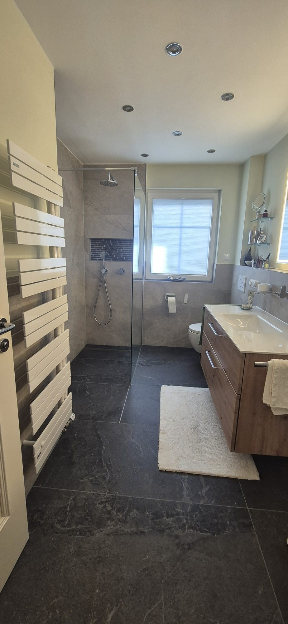 Modern saniertes Badezimmer mit bodengleicher Dusche, Waschtisch und Handtuchheizkörper in München